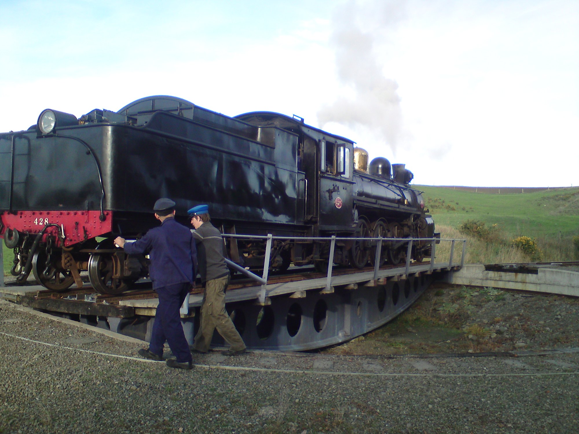 Volunteers turning locomotive A 428 on the turntable at Waikari with Canterbury farmland behind